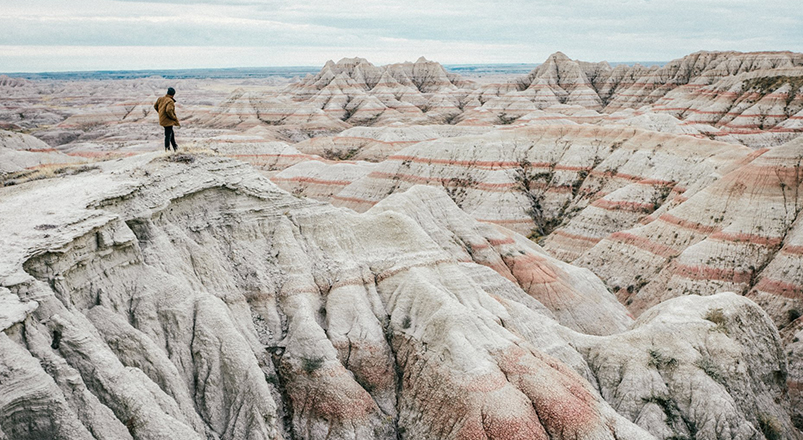 Hiker standing atop the Badlands in South Dakota.